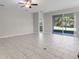 Open living room boasts tile floors, ceiling fan, neutral paint, and sliding glass door to the backyard at 405 E Freesia Ct, Deland, FL 32724