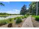 Scenic view of the lake with a paved walking path and gazebo, surrounded by lush greenery and offering a peaceful retreat at 405 E Freesia Ct, Deland, FL 32724