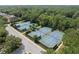 Aerial view featuring community tennis courts surrounded by lush landscaping and trees at 405 E Freesia Ct, Deland, FL 32724