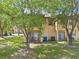 Townhome backyard with a covered patio and balcony, surrounded by mature trees at 4143 Calabria Ave, Davenport, FL 33897