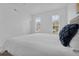 Bright bedroom with white walls, two large windows, and a comfortable bed with navy pillows at 4143 Calabria Ave, Davenport, FL 33897