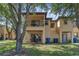 Two-story home featuring a balcony and patio overlooking lush greenery at 4143 Calabria Ave, Davenport, FL 33897