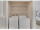 Conveniently located laundry area with modern washer and dryer units and wire shelving at 4143 Calabria Ave, Davenport, FL 33897