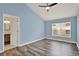 Spacious bedroom with vaulted ceilings, a ceiling fan, wood-look floors, and a connecting bathroom at 4406 Brookstone Ct, Orlando, FL 32826