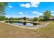 Beautiful view of the pond with lush greenery, blue skies, and clouds in the neighborhood at 4406 Brookstone Ct, Orlando, FL 32826