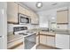 Efficient kitchen featuring white cabinets, essential appliances, and a functional layout at 46 Silver Falls Cir, Kissimmee, FL 34743