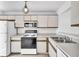 Functional kitchen with white cabinets, essential appliances, and ample counter space at 46 Silver Falls Cir, Kissimmee, FL 34743