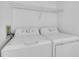 Convenient laundry area featuring a washer, dryer, and shelving for storage at 46 Silver Falls Cir, Kissimmee, FL 34743