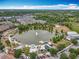Aerial view of a community lake, fountain, recreation area, and residences with lush greenery around at 473 Oviedo Blvd, Oviedo, FL 32765