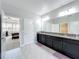 Bathroom with double vanity, granite countertop, tile floors, and access to the main bedroom at 473 Oviedo Blvd, Oviedo, FL 32765