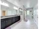 Bathroom with dual vanity, granite countertops, shower, tile floors, and ample natural light at 473 Oviedo Blvd, Oviedo, FL 32765