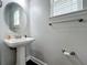 Simple bathroom features a pedestal sink, modern fixtures, and a neutral color scheme at 473 Oviedo Blvd, Oviedo, FL 32765