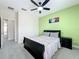 Neutral bedroom showcasing a cozy bed, with light green accent wall, and a black ceiling fan at 473 Oviedo Blvd, Oviedo, FL 32765