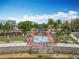 Community park with splashpad, green lawn, palm trees, and seating next to water at 473 Oviedo Blvd, Oviedo, FL 32765