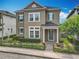 Charming two-story home featuring a manicured lawn, complemented by vibrant flowerbeds and a secure, decorative black metal fence at 473 Oviedo Blvd, Oviedo, FL 32765