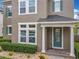 Inviting home exterior with manicured landscaping, decorative fence, and a charming front porch with stately white columns at 473 Oviedo Blvd, Oviedo, FL 32765