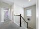Carpeted upstairs hallway with neutral walls, white railing, and archway leading to a room at 473 Oviedo Blvd, Oviedo, FL 32765