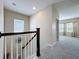 Upstairs hallway with white railing, leading into a carpeted bonus room, and featuring lots of natural light at 473 Oviedo Blvd, Oviedo, FL 32765