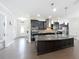Kitchen featuring dark cabinetry, stainless appliances, granite countertops, hardwood floors and eat-in island at 473 Oviedo Blvd, Oviedo, FL 32765