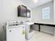 Functional laundry room equipped with washer, dryer, overhead cabinets and a folding table at 473 Oviedo Blvd, Oviedo, FL 32765