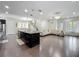Open floor plan with dark hardwood flooring, ample lighting, and a spacious living area connected to a large kitchen island at 473 Oviedo Blvd, Oviedo, FL 32765
