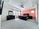 Bright main bedroom featuring plush carpeting, a tray ceiling, and a modern furniture set at 473 Oviedo Blvd, Oviedo, FL 32765