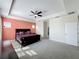 Spacious main bedroom with carpeting, modern furniture set, tray ceiling, and ensuite bathroom at 473 Oviedo Blvd, Oviedo, FL 32765