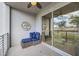 Inviting outdoor balcony with comfortable wicker seating with blue cushions and sliding glass doors at 4731 Clock Tower Dr # 105, Kissimmee, FL 34746