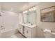 Well-lit bathroom with double sink vanity, large mirror, and a bathtub with shower, offering comfort and convenience at 4731 Clock Tower Dr # 105, Kissimmee, FL 34746
