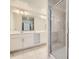 Modern bathroom featuring double sinks, white cabinets, and a glass-enclosed shower at 4731 Clock Tower Dr # 105, Kissimmee, FL 34746
