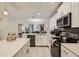 Bright kitchen featuring white cabinets, stainless steel appliances and an island with hanging lights at 4731 Clock Tower Dr # 105, Kissimmee, FL 34746