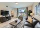 Comfortable living room featuring a dark leather sofa, accent chair, modern furniture, and outdoor view at 4731 Clock Tower Dr # 105, Kissimmee, FL 34746