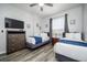 Bright bedroom with twin beds, dresser and a TV with neutral decor at 4802 Cayview Ave # 301, Orlando, FL 32819