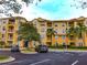 View of a multi-story condo building with balconies, landscaping, and parking lot at 4802 Cayview Ave # 301, Orlando, FL 32819