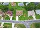 A bird's eye view showcases a house in a verdant neighborhood with manicured lawns and mature trees at 5076 Nw 21St Loop, Ocala, FL 34482