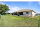 Backyard view shows house, lawn, plants and satellite dish with fence separating neighbors' yards at 5076 Nw 21St Loop, Ocala, FL 34482