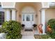 Close-up of an ornate front door entrance with decorative columns, plants, and stylish heron ornaments at 5076 Nw 21St Loop, Ocala, FL 34482