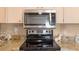 Stainless steel microwave and smooth-top stove compliment the granite countertops in this well-equipped kitchen at 5076 Nw 21St Loop, Ocala, FL 34482