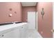 Functional laundry room with modern appliances, and ample space for laundry tasks with pink walls at 5076 Nw 21St Loop, Ocala, FL 34482