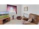 Relaxing living room with a comfortable recliner, TV, and scenic view outside the window at 5076 Nw 21St Loop, Ocala, FL 34482