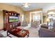 Cozy living room showcasing a large entertainment center, floral armchairs, and a decorative glass-top coffee table at 5076 Nw 21St Loop, Ocala, FL 34482