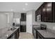 Modern kitchen with stainless steel appliances, granite countertops, and dark wood cabinets at 523 Tortugas St, Haines City, FL 33844