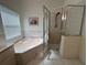 Bright primary bathroom features a large soaking tub and a walk-in shower at 5604 Loma Vista W Dr, Davenport, FL 33896