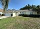 Well-maintained home boasting a large front lawn, two-car garage, and manicured shrubbery at 5604 Loma Vista W Dr, Davenport, FL 33896