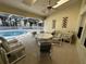 Covered patio with a dining table and chairs adjacent to the pool at 5604 Loma Vista W Dr, Davenport, FL 33896