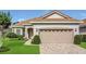 Charming home featuring a two-car garage, neutral paint, brick driveway, manicured lawn, and mature landscaping at 578 Newhall Ln, Debary, FL 32713