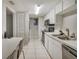 Galley style kitchen featuring white cabinets and modern appliances at 5833 La Costa Dr # S, Orlando, FL 32807