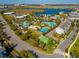 Aerial view of community featuring multiple pools, sports courts, and a scenic lake at 7789 Nemours Pkwy, Orlando, FL 32827