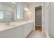 Bright bathroom features a double vanity with white cabinets and countertop, and a glass-enclosed shower at 7789 Nemours Pkwy, Orlando, FL 32827