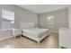 Bright bedroom featuring wood floors, a white bed frame, and a window with modern blinds at 7789 Nemours Pkwy, Orlando, FL 32827